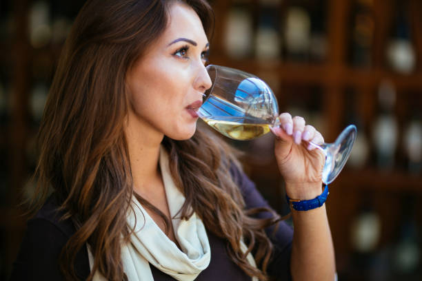 Portrait of beautiful woman tasting wine a wine cellar