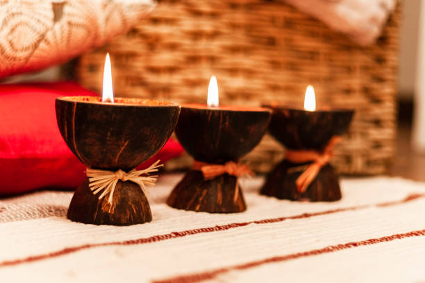 istock Burning spa aroma candles in coconut shell, pillows and plaid, cozy home interior background 1085344754