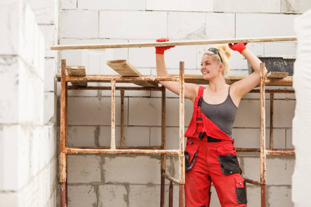 istock Woman carrying plank boards on construction site 1085347082