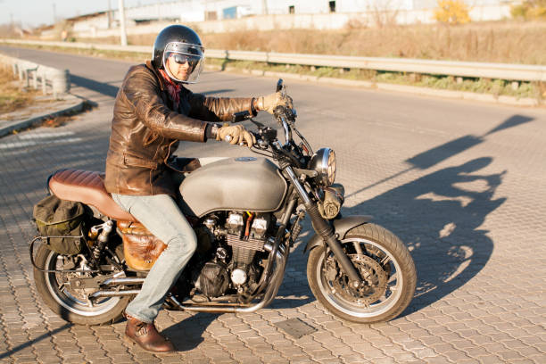istock Man and old custom cafe-racer Motorcycle on forest  at sunset 1085352556