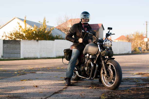 istock Man and old custom cafe-racer Motorcycle on forest  at sunset 1085352712