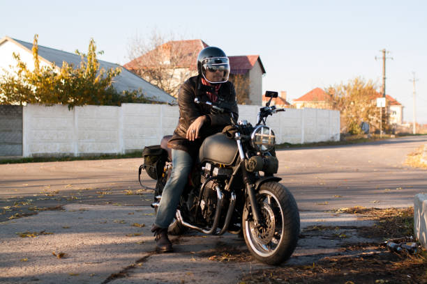 istock Man and old custom cafe-racer Motorcycle on forest  at sunset 1085352716