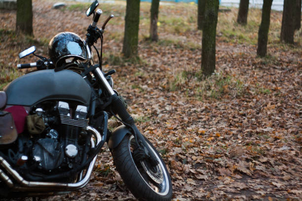 istock Man and old custom cafe-racer Motorcycle on forest  at sunset 1085352974