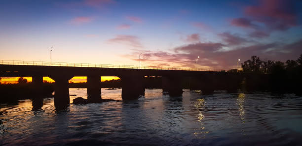 istock Scenic sunset behind a river bridge silhouette 1085353384