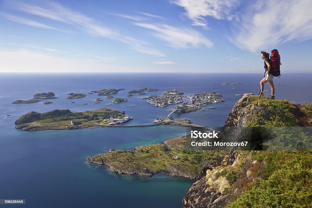 climber on top climber on top of rock near bay of ocean Achievement Stock Photo