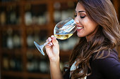 Portrait of female sommelier smelling wine before tasting it at wine cellar