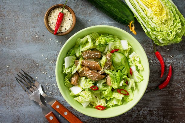 diet menu. healthy salad with chinese cabbage, chicken, sesame and chili pepper on a dark stone table. top view flat lay background. - 16330 imagens e fotografias de stock