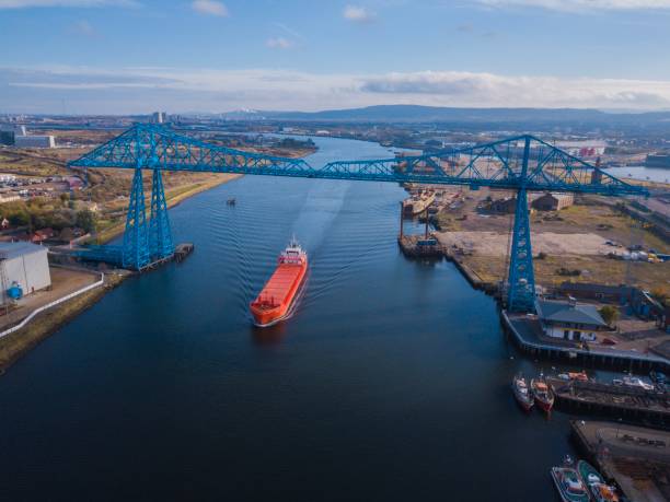 The historic Teesside transporter bridge with large bulk carrier ship sailing under it. Photo taken by drone