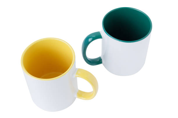 istock Two white mugs, with a green and yellow handle on a white background.  Isolated. 1085362976