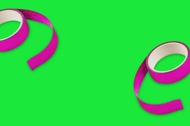 Two rolls of violet sticky tapes on green background with copy space for your text