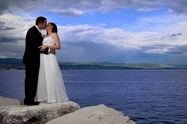 Wedding couple by the sea, dramatic sky