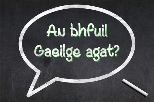 Blackboard with a bubble drawn in the middle with the short phrase in Irish 
