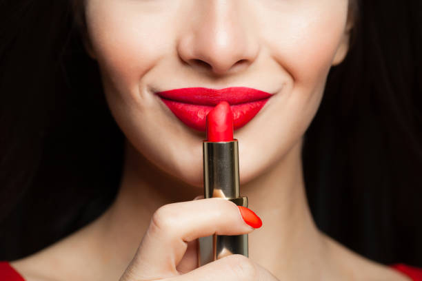 istock Female face closeup. Red lips makeup with bright red lipstick on black background 1085386330