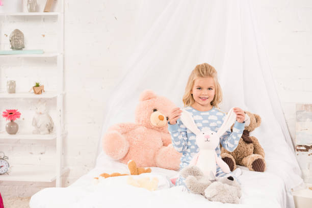 istock smiling cute child playing with soft toys in bed 1085391628