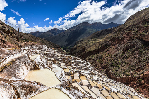 The white terraces of Salinas de Maras salt mines are located on the steep slopes of the Andes mountains.