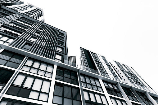 Black and white low angle view of new high rise apartment buildings, sky background with copy space, Wolli Creek, Australia, full frame horizontal composition