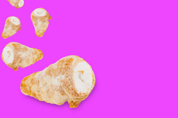istock Falling baked rolls with cream on violet background with copy space for your text 1085398442