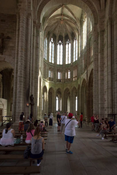 Chapel of Notre-Dame-sous-Terre at Mont Saint Michel abbey, France Visitors at the Chapelle Notre-Dame-sous-Terre at Mont Saint Michel abbey. Le Mont-Saint-Michel is an island commune in Normandy, France. It is located about one kilometre (0.6 miles) off the country's northwestern coast, at the mouth of the Couesnon River near Avranches. sous terre stock pictures, royalty-free photos & images