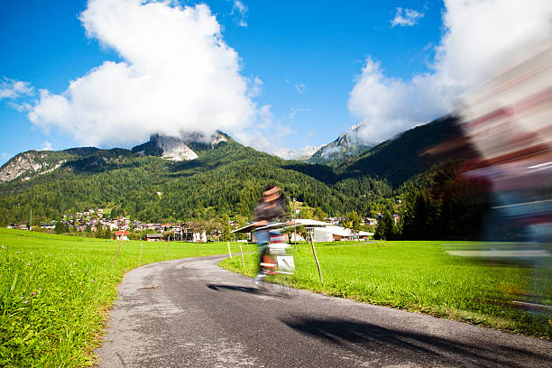 People drive a bicycle in mountain Alps in their free time