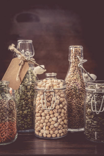 Various dry legumes,pumpkin seeds, almonds, in a glass jar