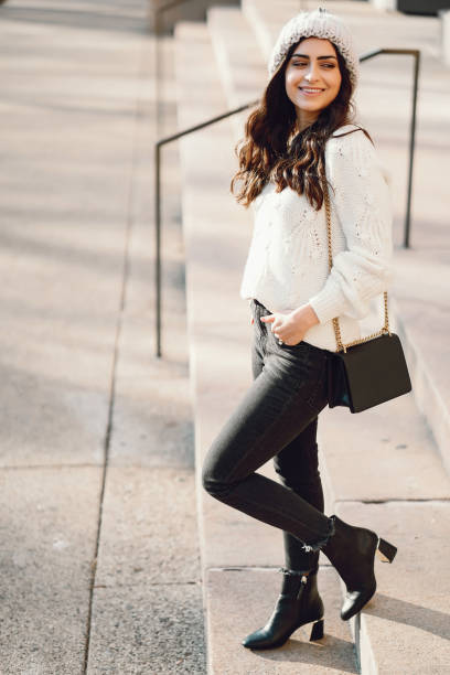 istock Cute brunette in a white sweater in a city 1085439458