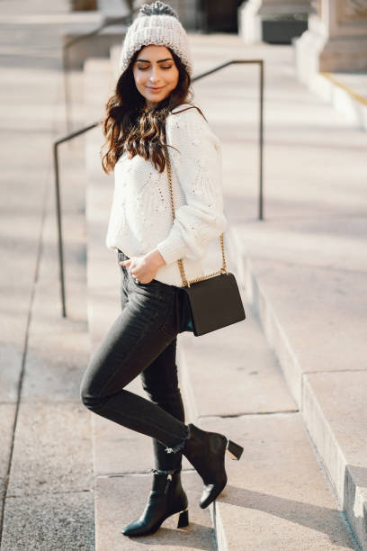 istock Cute brunette in a white sweater in a city 1085439472