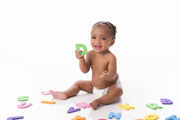 Smiling Baby Girl Playing with Letter Toys stock photo