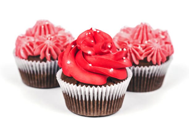 istock Three cupcakes with red and pink icing on isolated white background. 1085439970