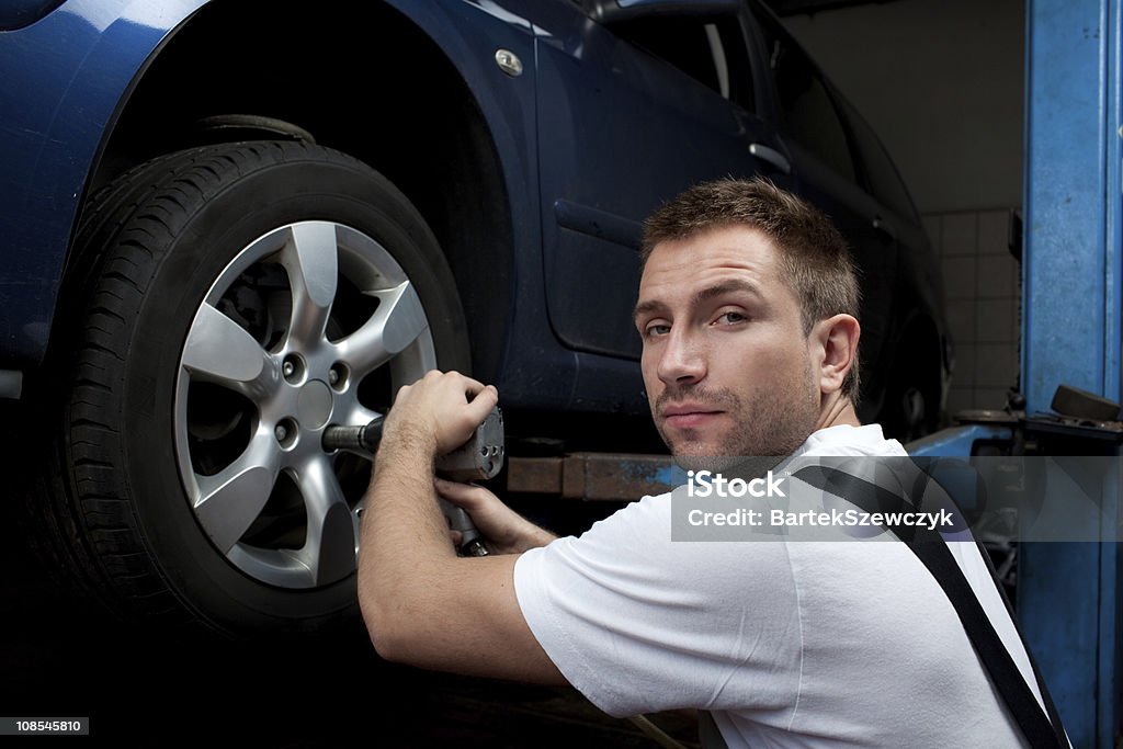 Reparador cambio de rueda - Foto de stock de Adulto joven libre de derechos