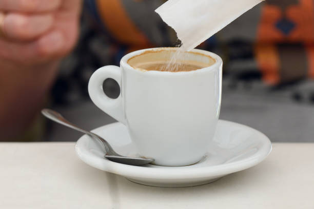 istock sugar is poured into a cup of coffee 1085462598
