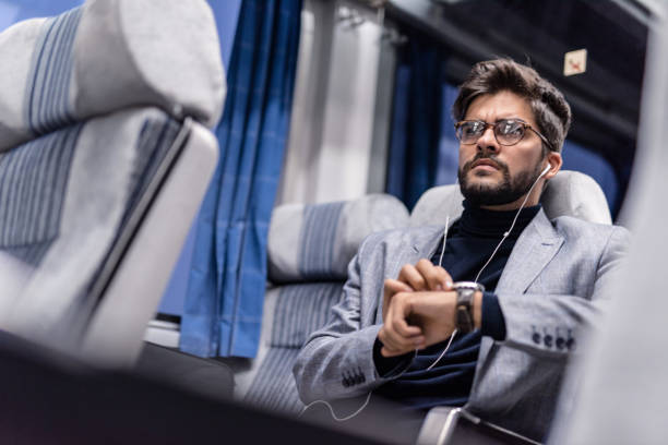 istock Young man checking time and listening to podcasts while traveling by train. 1085464942