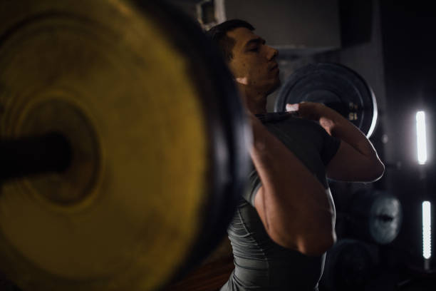 istock Guy weightlifting in dark gym 1085465144