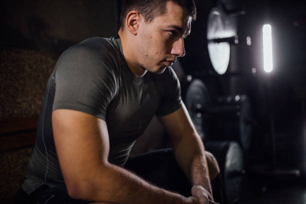 istock Man sitting in dark gym 1085466316