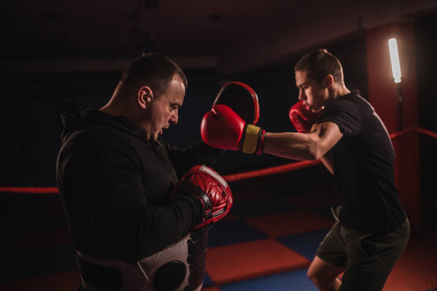 istock Young boxer training with coach in gym 1085468312
