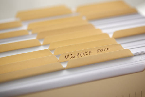 Yellow folders with labels and paper in a row in the insurance file closeup