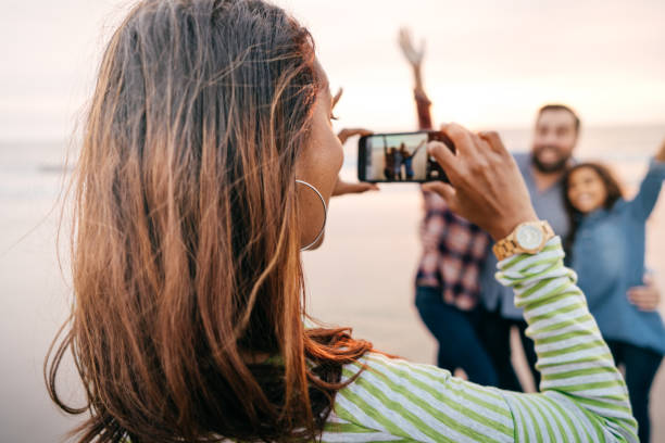 istock Family on the beach taking photos 1085472212