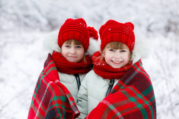 istock Children twins are standing covered with plaid. 1085474840