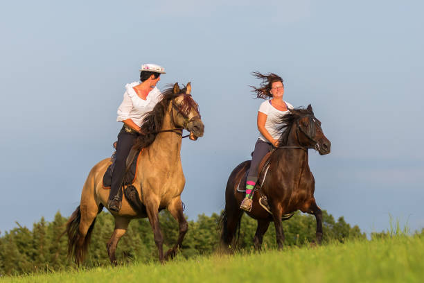 istock two women riding horses 1085479530