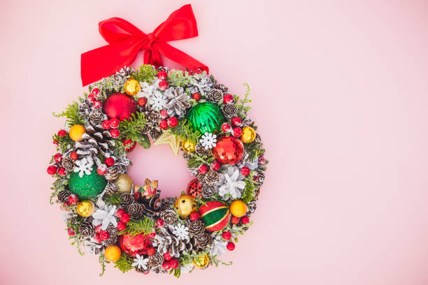 istock Top view Beautiful traditional bright Christmas wreath decorated with pine cones, spruce branches,berries, balls, stars and decorative beers on pink background isolated, flat lay. Copy space. 1085494706