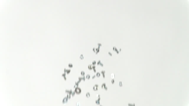 Nuts, bolts and washers being tossed in the air, slow motion, repeat