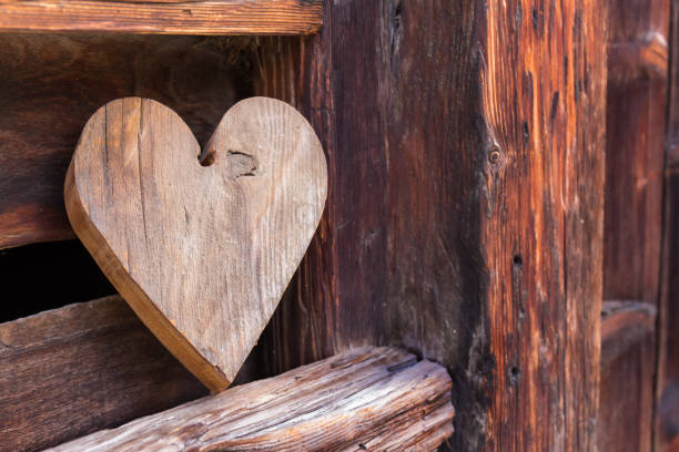 cuore di legno al di fuori di un fienile rustico come segno di benvenuto - barn red old door foto e immagini stock