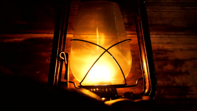 Hand turn on Lantern lamp at night