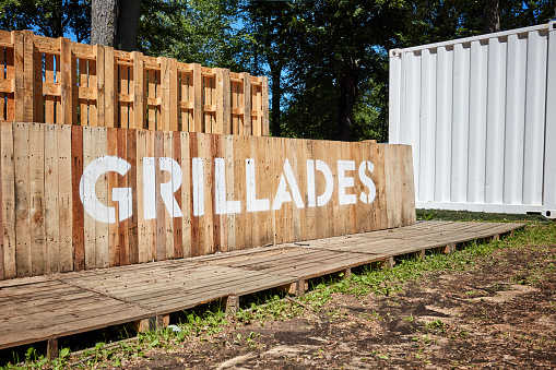 Vintage wooden outdoor grill counter. The word Grillades is written with white paint on it.