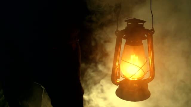 Man hand holding a kerosene lamp at night
