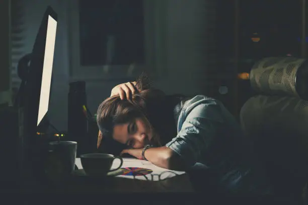 Photo of Portrait of Asian Businesswoman sitting and working hard on the table with front of computer desktop in workplace at late with serious action, Work hard and too late concept