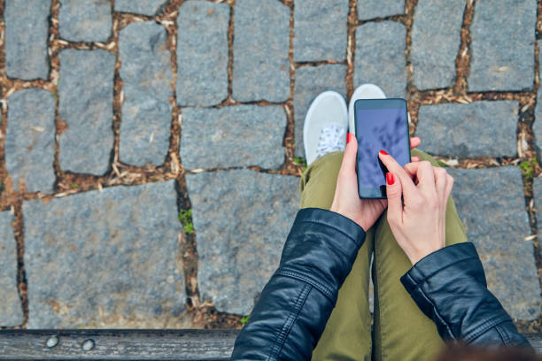 istock Woman sitting on a bench and using smartphone. 1085569710