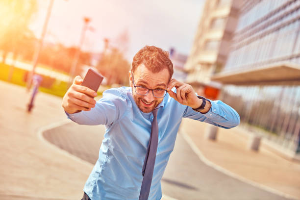 istock Funny businessman with thumbs up while using smartphone outdoors. 1085571922
