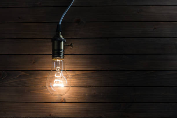 istock The light bulb illuminates on wooden background 1085575954