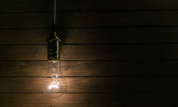istock The light bulb illuminates on wooden background 1085576020