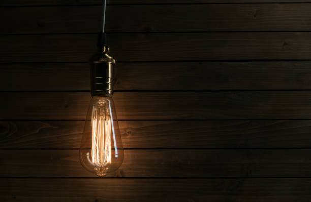 istock The light bulb illuminates on wooden background 1085576292